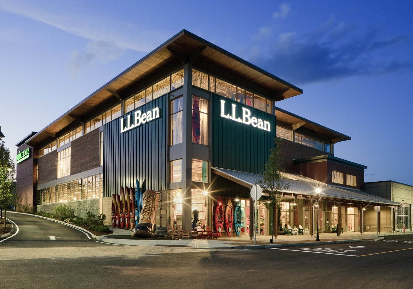 L.L.Bean store at dusk with vertical metal panel, wood-tone siding and a timber roof overhang